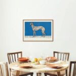 Artistic woodcut print by Moriz Jung featuring a detailed depiction of a slender greyhound dog standing in profile, set against a vibrant blue background with subtle white markings resembling a snowy ground.