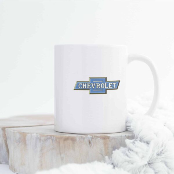 Glossy white 11oz Chevrolet logo coffee mug on kitchen counter.