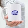 Classic white 11oz ceramic mug with Delage logo in bold blue, placed on a modern kitchen countertop.
