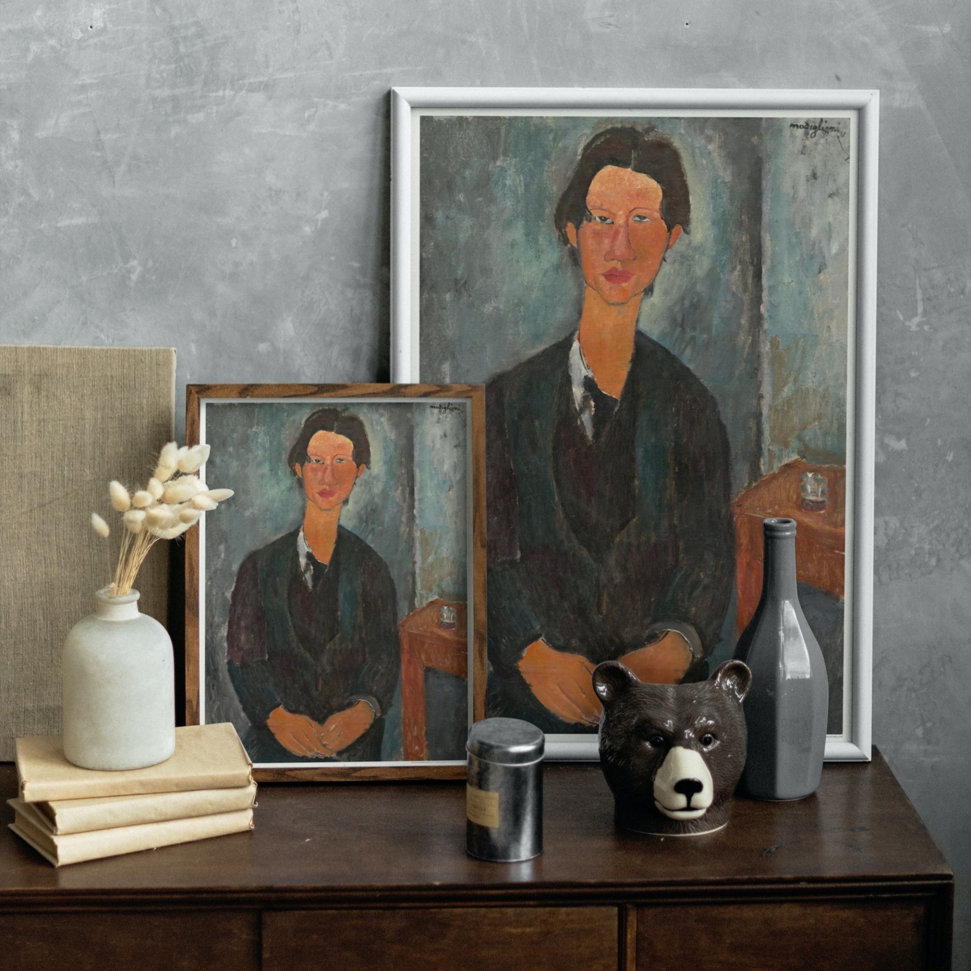 Portrait of Chaim Soutine by Amedeo Modigliani, displaying a figure with the artist's signature stylized and elongated form. The subject, Soutine, is portrayed with a contemplative gaze, dressed in a dark suit against a textured, neutral background, reflecting Modigliani's distinctive expressionistic style.