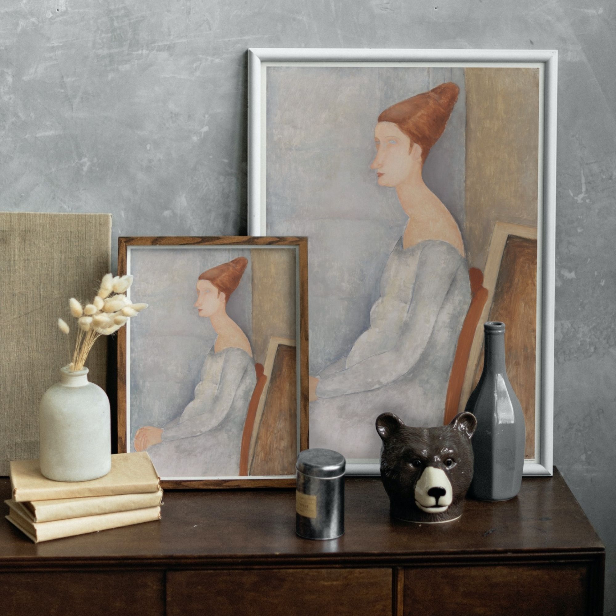Painting by Amedeo Modigliani of Jeanne Hébuterne, depicted with a characteristic elongated neck and a contemplative gaze. Her figure is adorned in a softly draped garment, with auburn hair styled in an updo, set against a muted backdrop that emphasizes the subject's ethereal beauty and Modigliani's distinctive use of form and color.