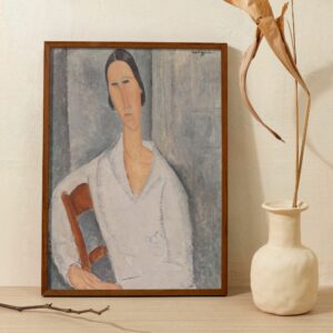 Striking Modigliani painting of Madame Hanka Zborowska, featuring the artist's characteristic style with elongated face and neck, and a somber expression. The subject is dressed in a white blouse with a muted background, highlighting Modigliani's focus on the quiet intensity of his sitters.