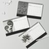 Karl Blossfeldt Desk Calendar featuring high-contrast black and white botanical photography prints, spiral-bound and displayed on a textured background for home or office decor.