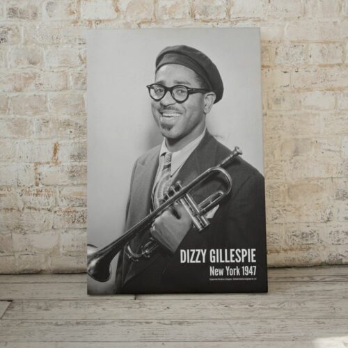 Black and white photo of Dizzy Gillespie holding a trumpet, titled DIZZY GILLESPIE New York 1947, featuring his iconic smile and beret, epitomizing the jazz era.