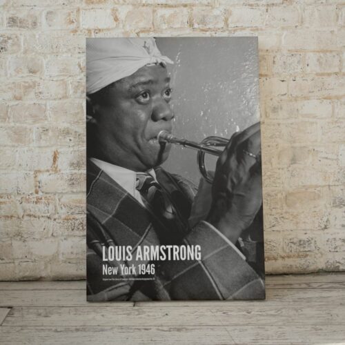 Black and white photo of Louis Armstrong playing trumpet, in plaid suit and white headband, titled LOUIS ARMSTRONG New York 1946, capturing intense performance and jazz essence.