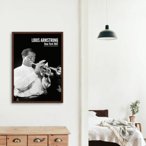 Black and white photo of Louis Armstrong playing trumpet, focused and skilled, titled LOUIS ARMSTRONG New York 1947, white shirt, conveying artistry and timeless jazz legacy.