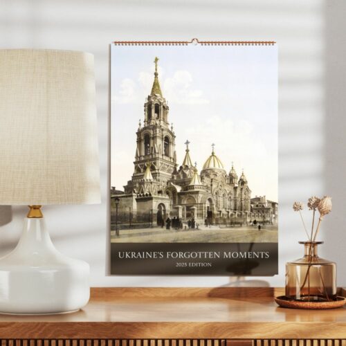Elegant calendar hangs on a well-lit room's wall showcasing a historical church from Ukraine, titled Ukraines Forgotten Moments 2025 Edition.