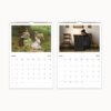 March and April 2025 on wall calendar featuring children in a meadow with lambs and a girl studying beside a stove