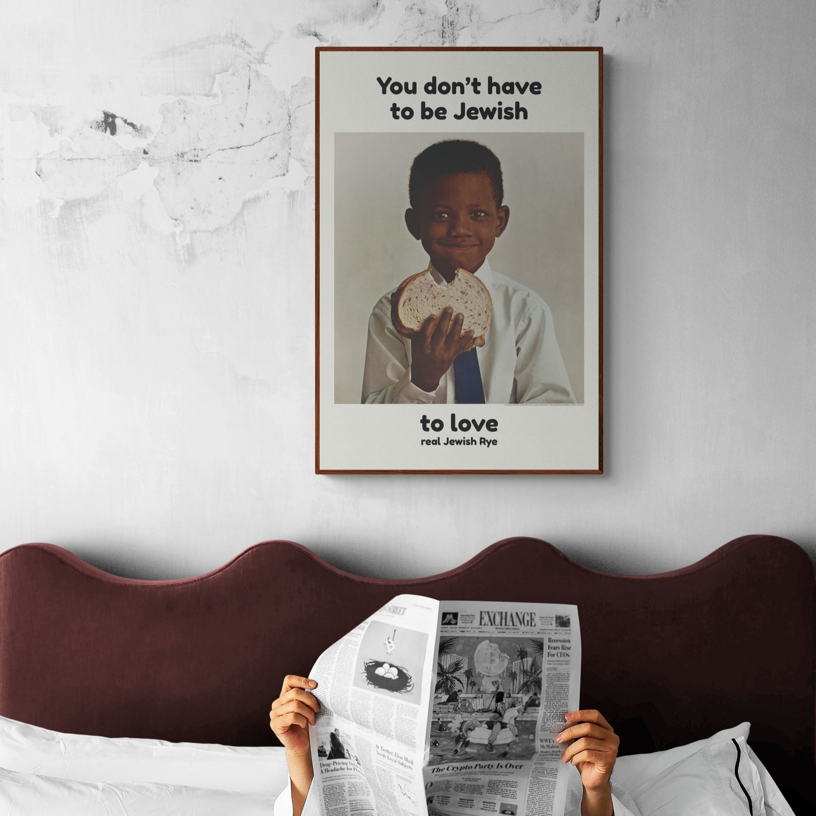 Person reading newspaper under vintage bread poster.