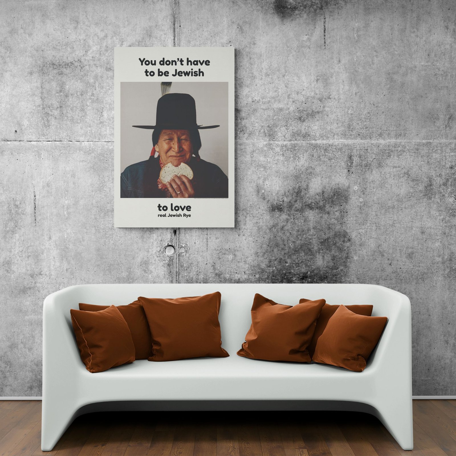 Poster on wall above white couch with brown pillows.