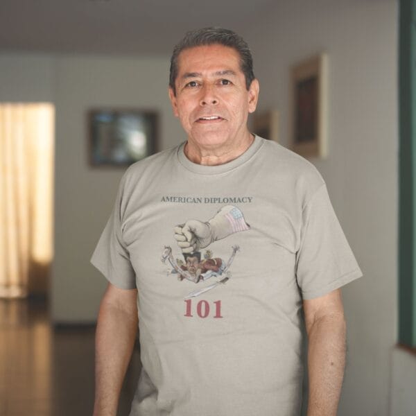 Man wearing American Diplomacy 101 t-shirt inside home.