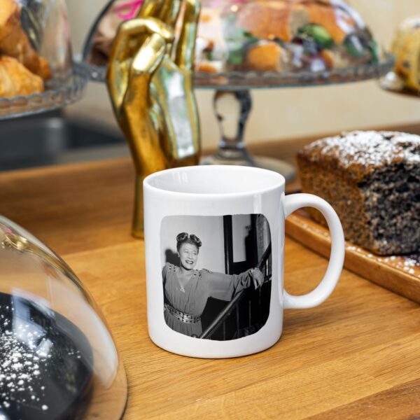 White mug with vintage photo of Ella Fitzgerald on wooden table.