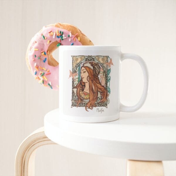 Coffee mug with decorative artwork and pink donut.
