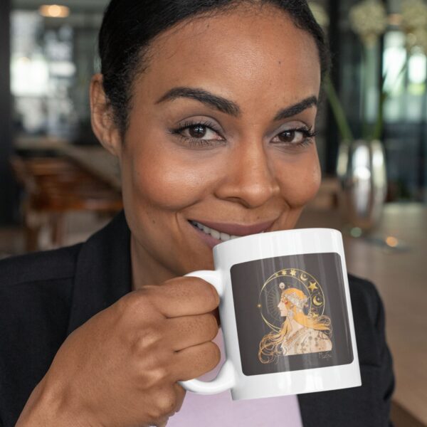 Woman smiling, holding mug with celestial portrait.