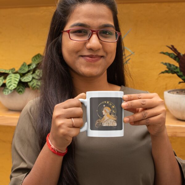 Person holding mug with artwork, yellow background.