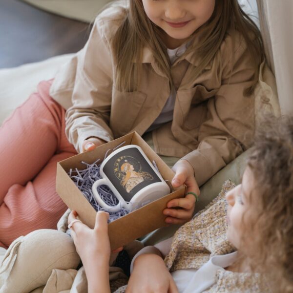 Two kids exchanging a decorated mug gift.