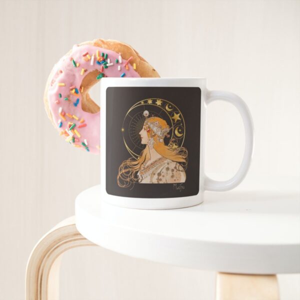 Mug with art and pink donut on table