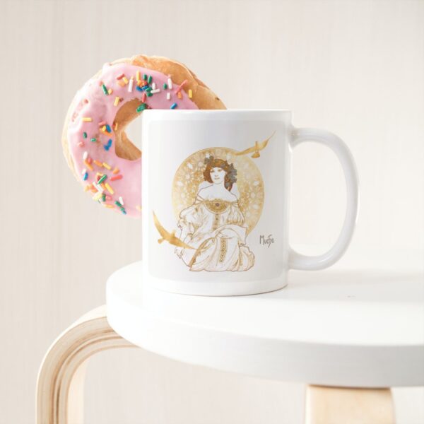 Pink donut resting on mug with art design.