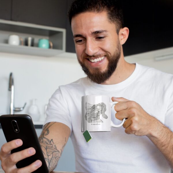 Smiling man holds mug, looks at smartphone.