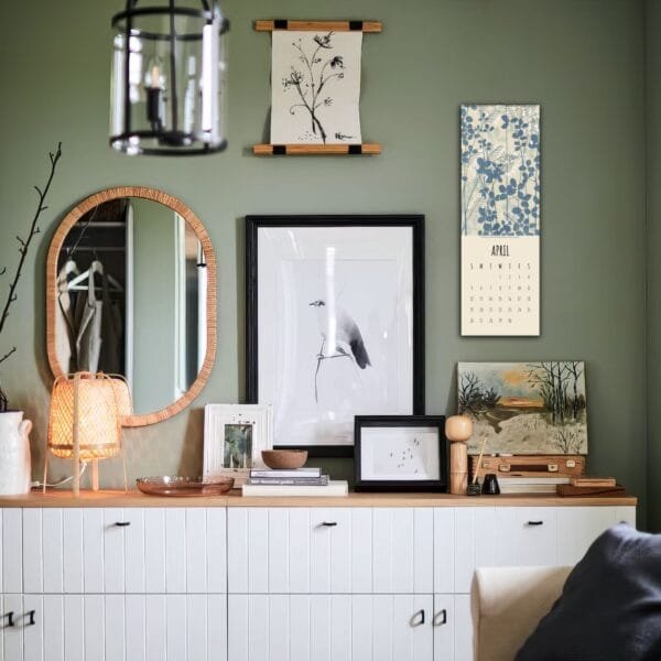 Wall with art, mirror, and calendar decor.