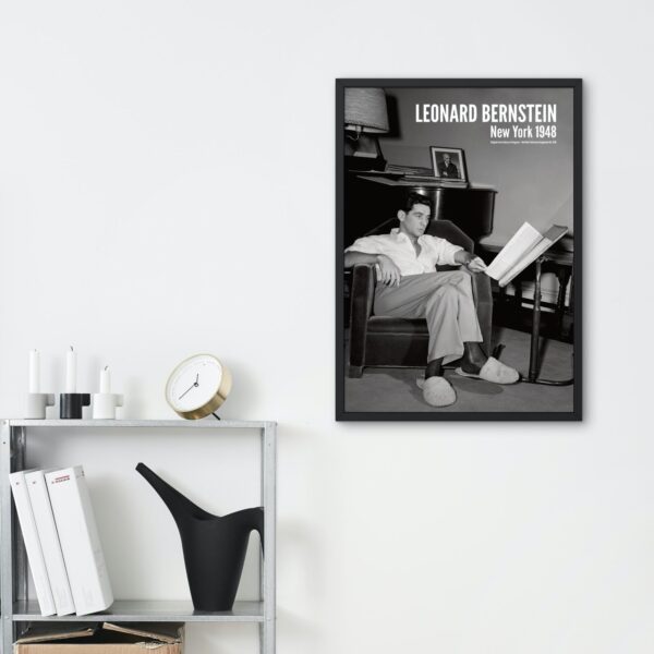 Framed portrait of Leonard Bernstein on wall, shelves with decor nearby.