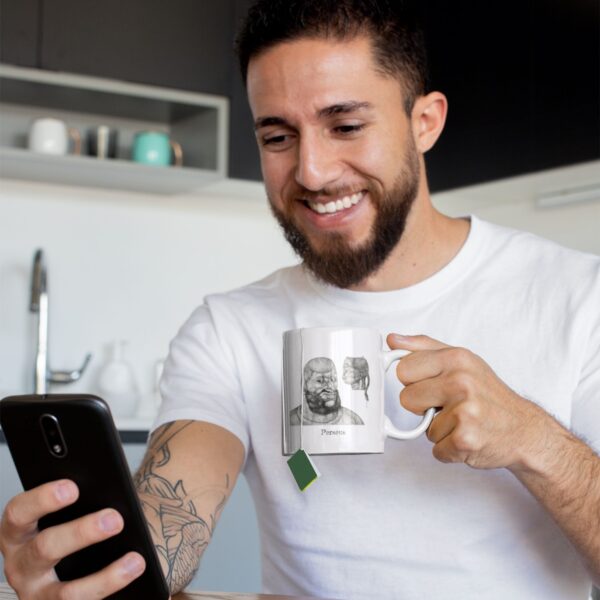 Man smiling, holding mug, checking phone at home.