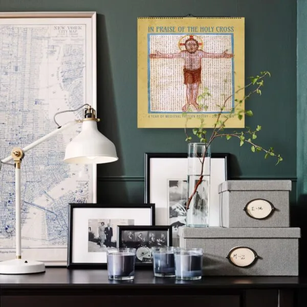 Decorative desk with lamp, calendar, and framed photos.