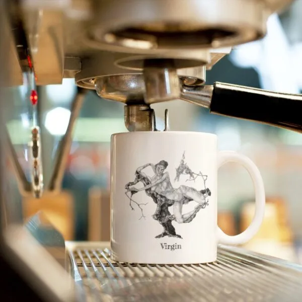 White mug under espresso machine with artistic design.
