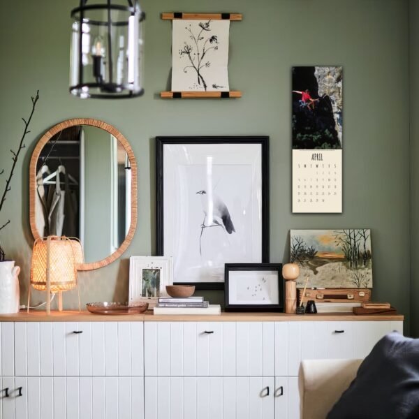 Decorated wall with art, mirror, and lamp.