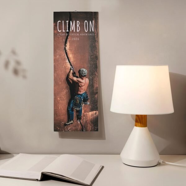Rock climber calendar near lamp and book