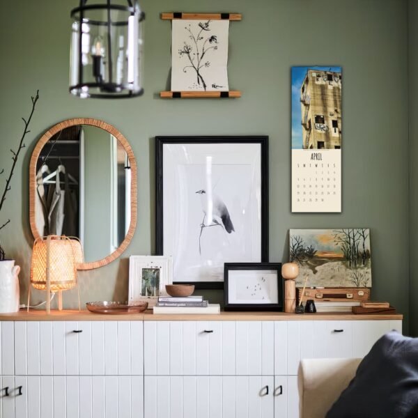Stylish room with art and decor on green wall.