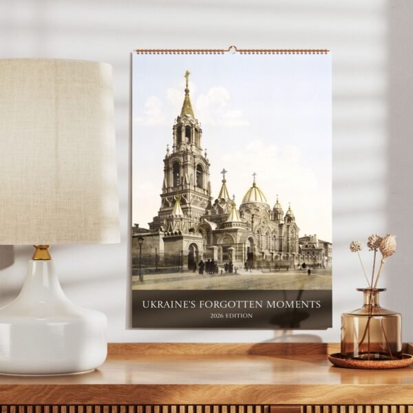 Calendar with historic Ukrainian church, lamp, and table decor.