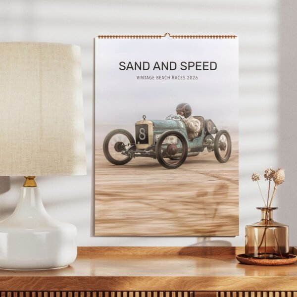 Vintage car racing poster on wall near lamp.