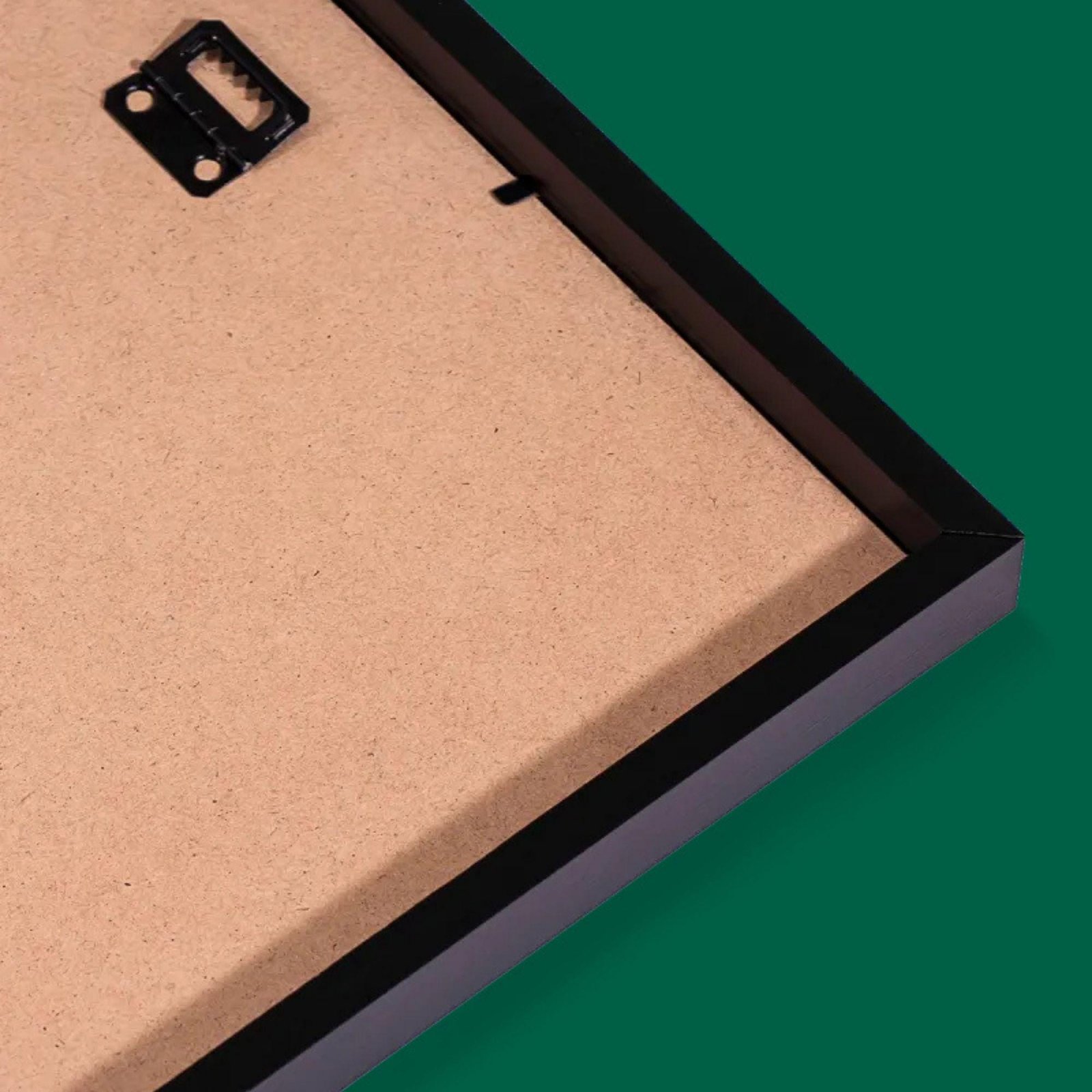 Back of a black-framed picture frame on green.