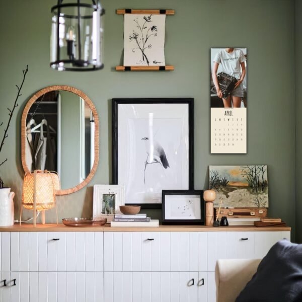 Decorated wall with art, mirror, and calendar.