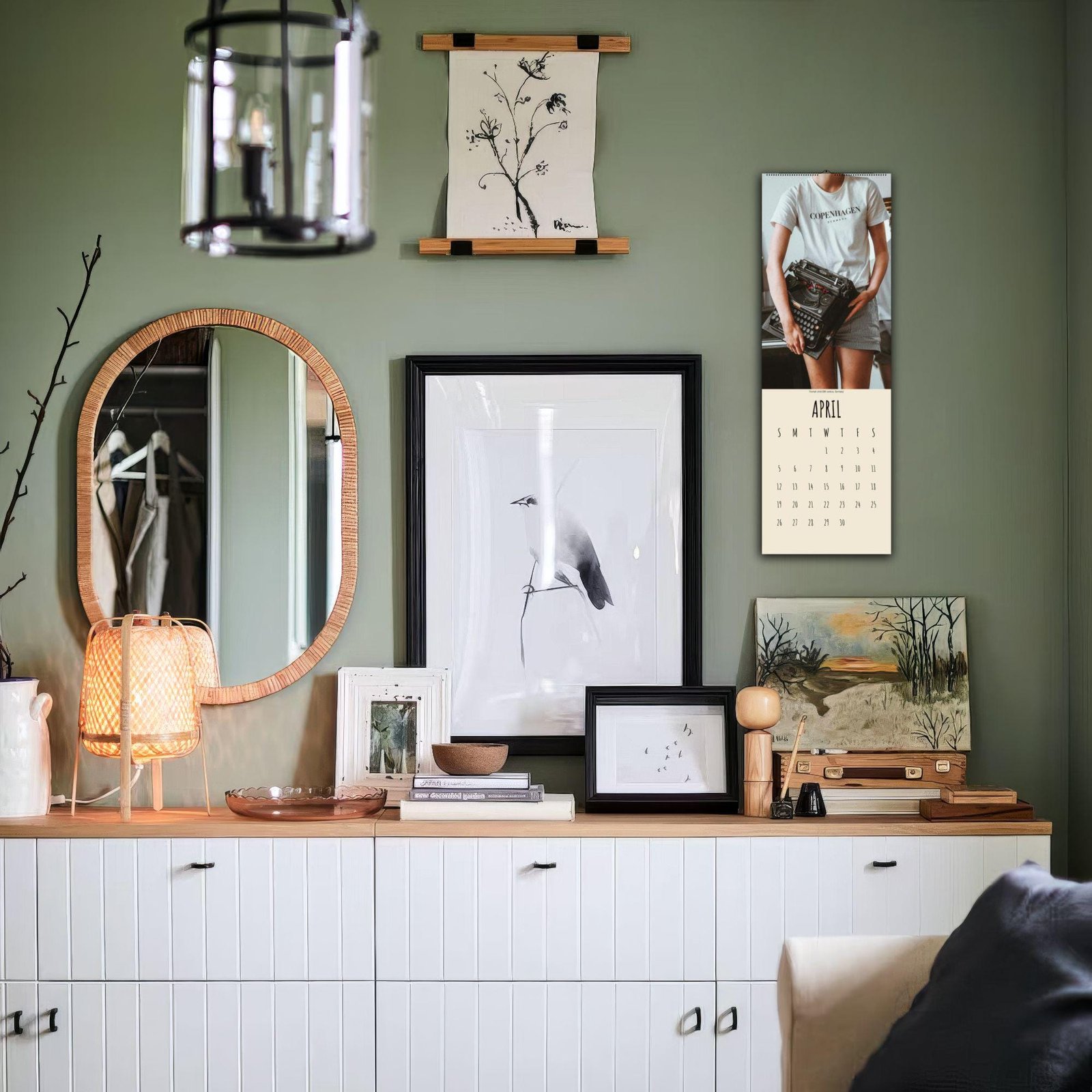 Decorated wall with art, mirror, and calendar.
