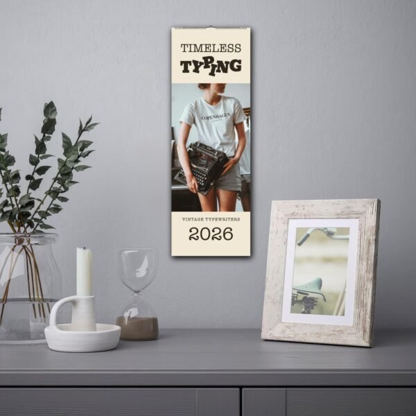 Vintage typewriters 2026 calendar on gray wall.