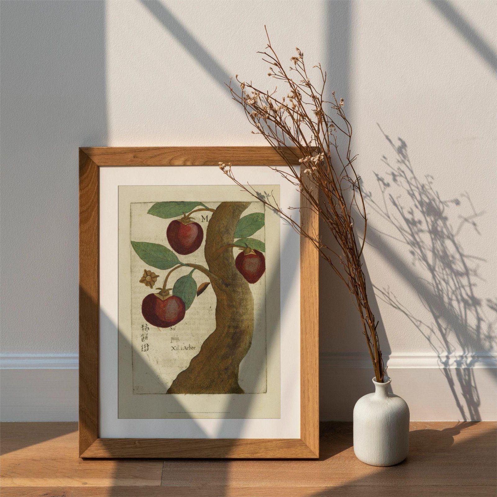 Framed apple tree art with vase and branches.
