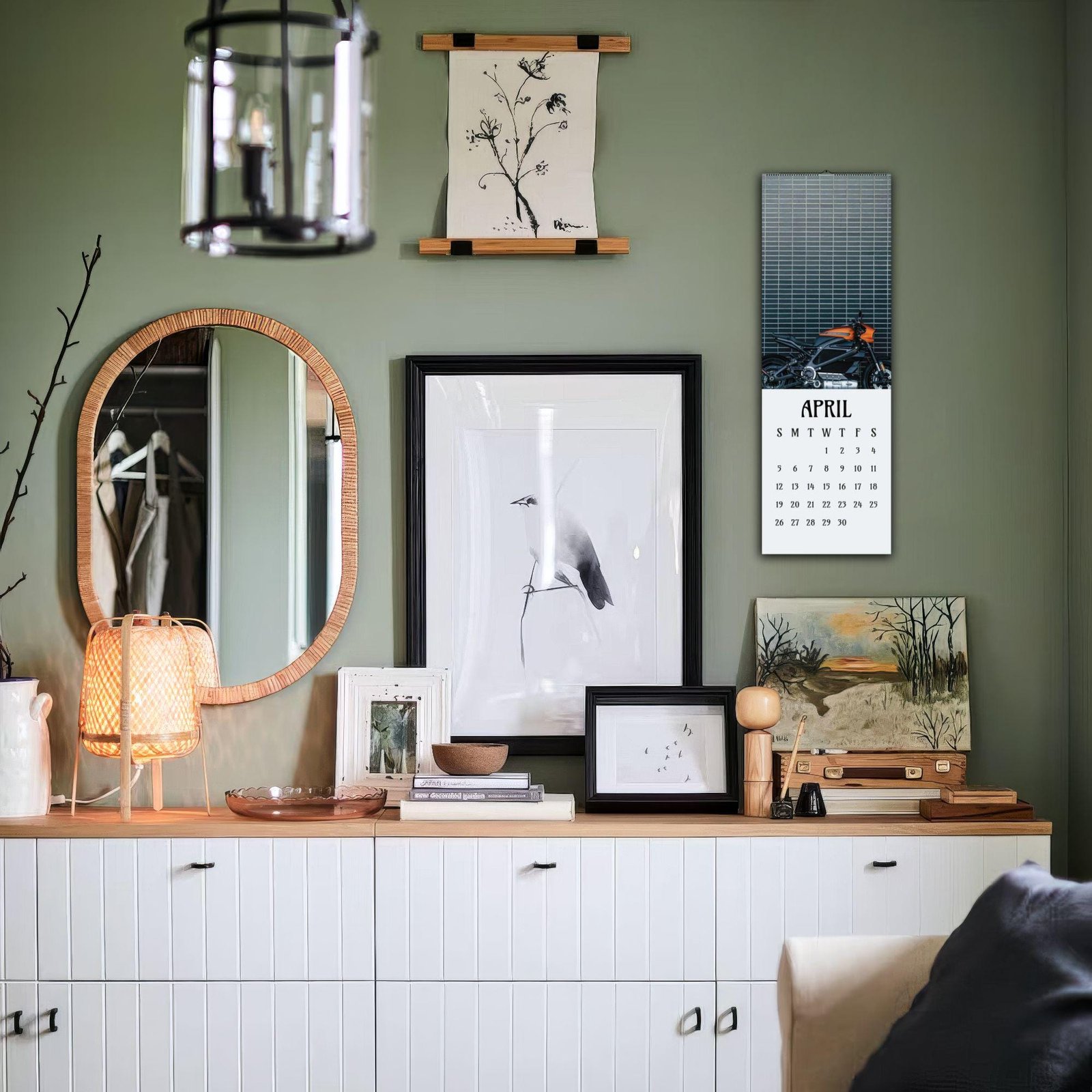 Styled wall with art, calendar, and mirror.