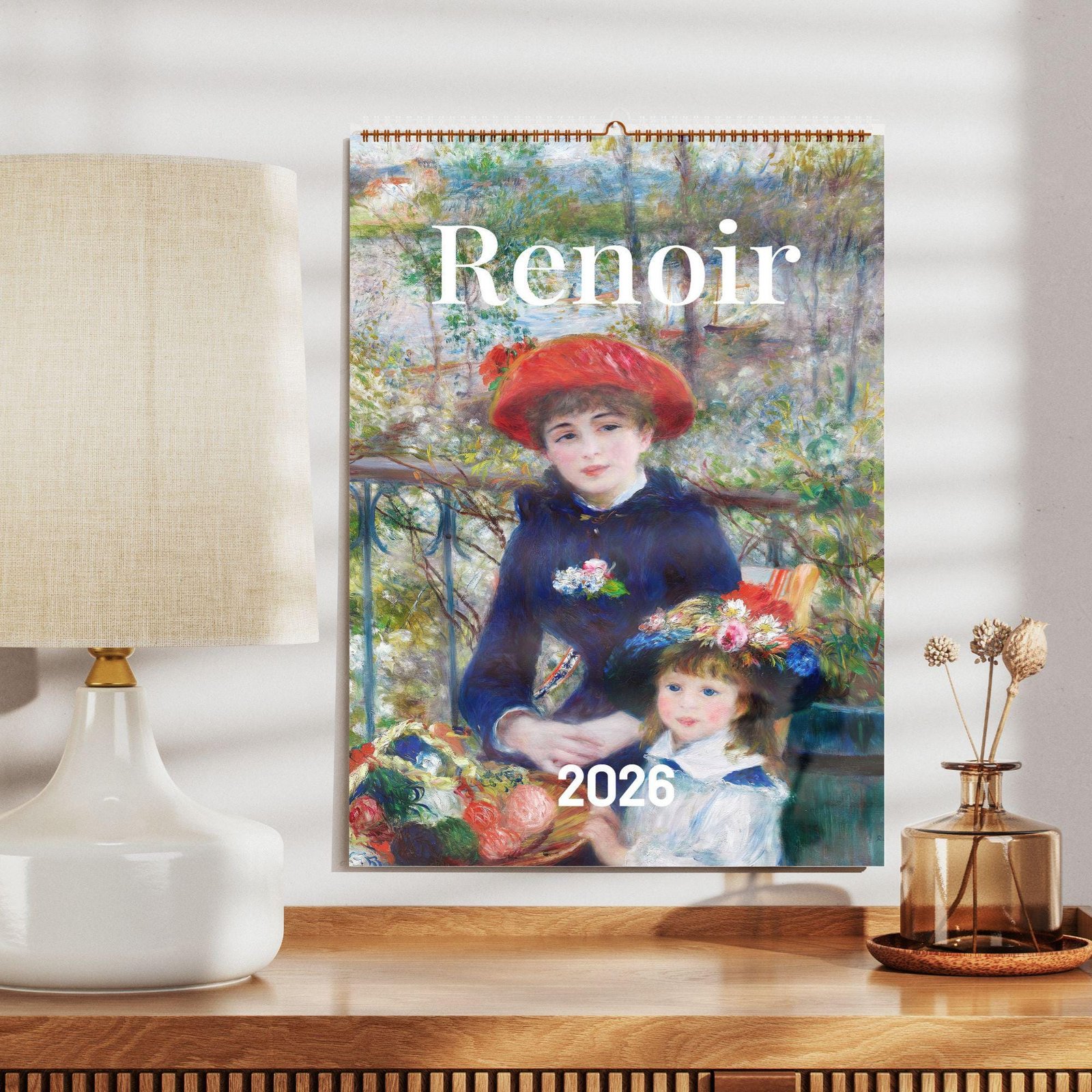 Renoir 2026 calendar beside a table lamp