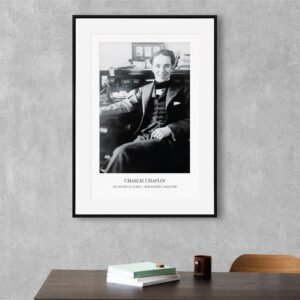 Framed Charlie Chaplin portrait on gray wall.