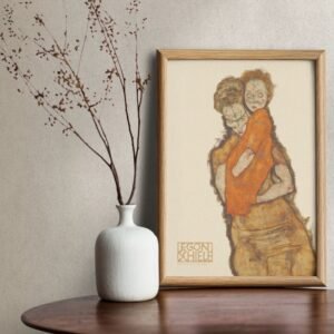 Framed painting beside white vase on wooden table.