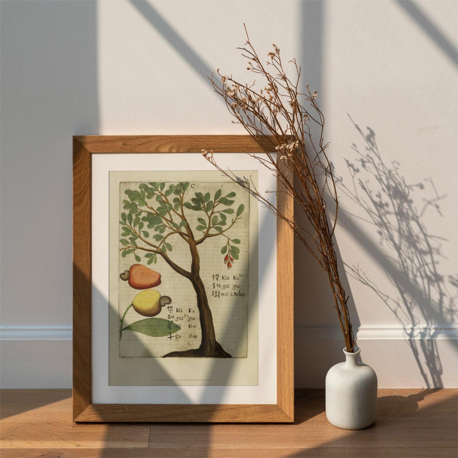 Framed botanical art with vase on wooden floor.