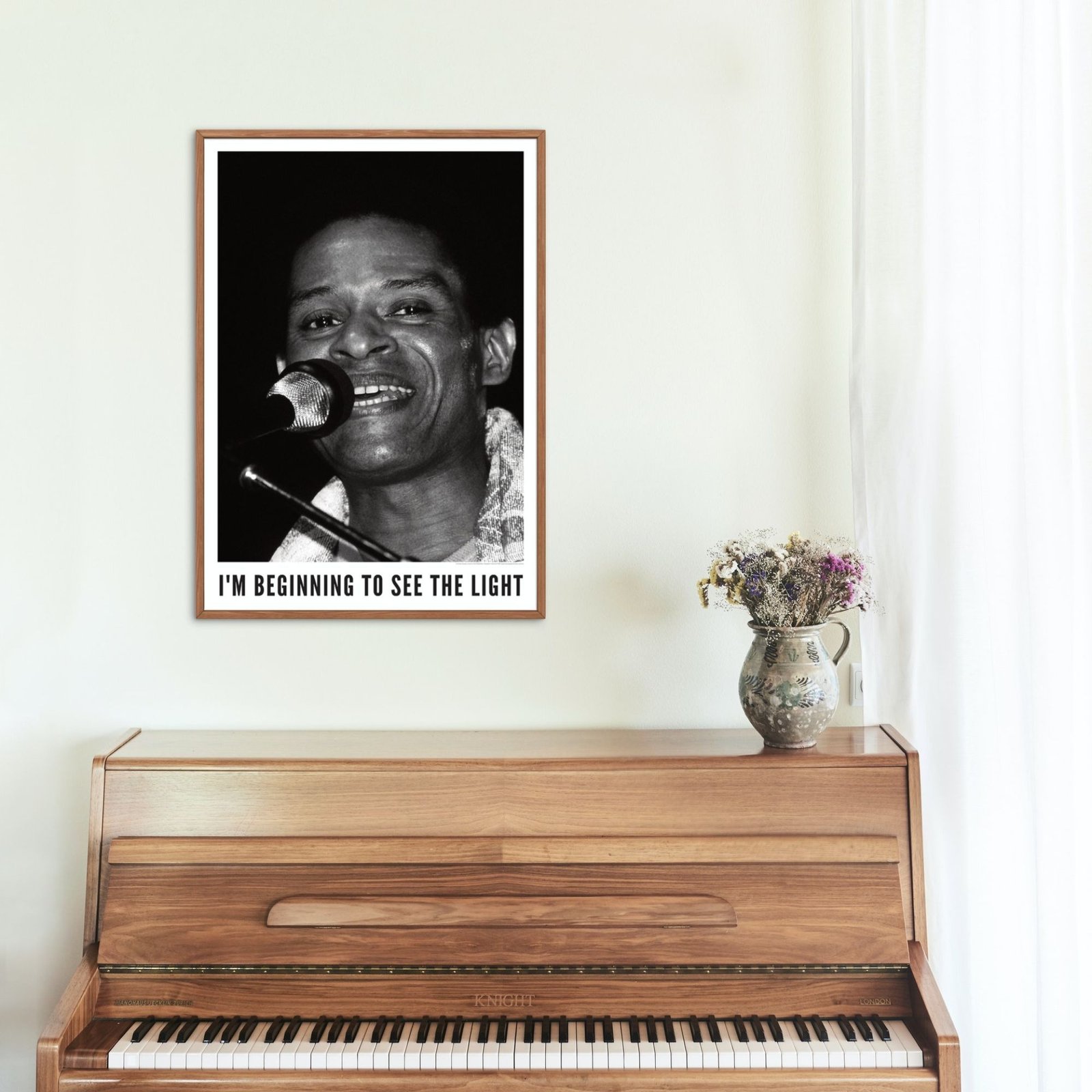 Black-and-white portrait above wooden piano.