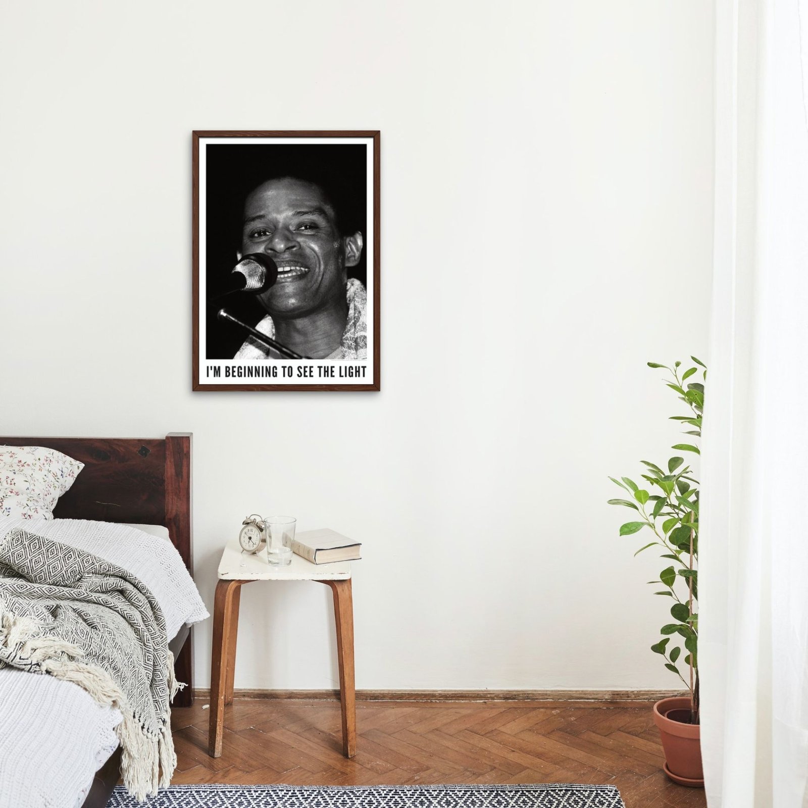Black and white portrait on wall above bed.