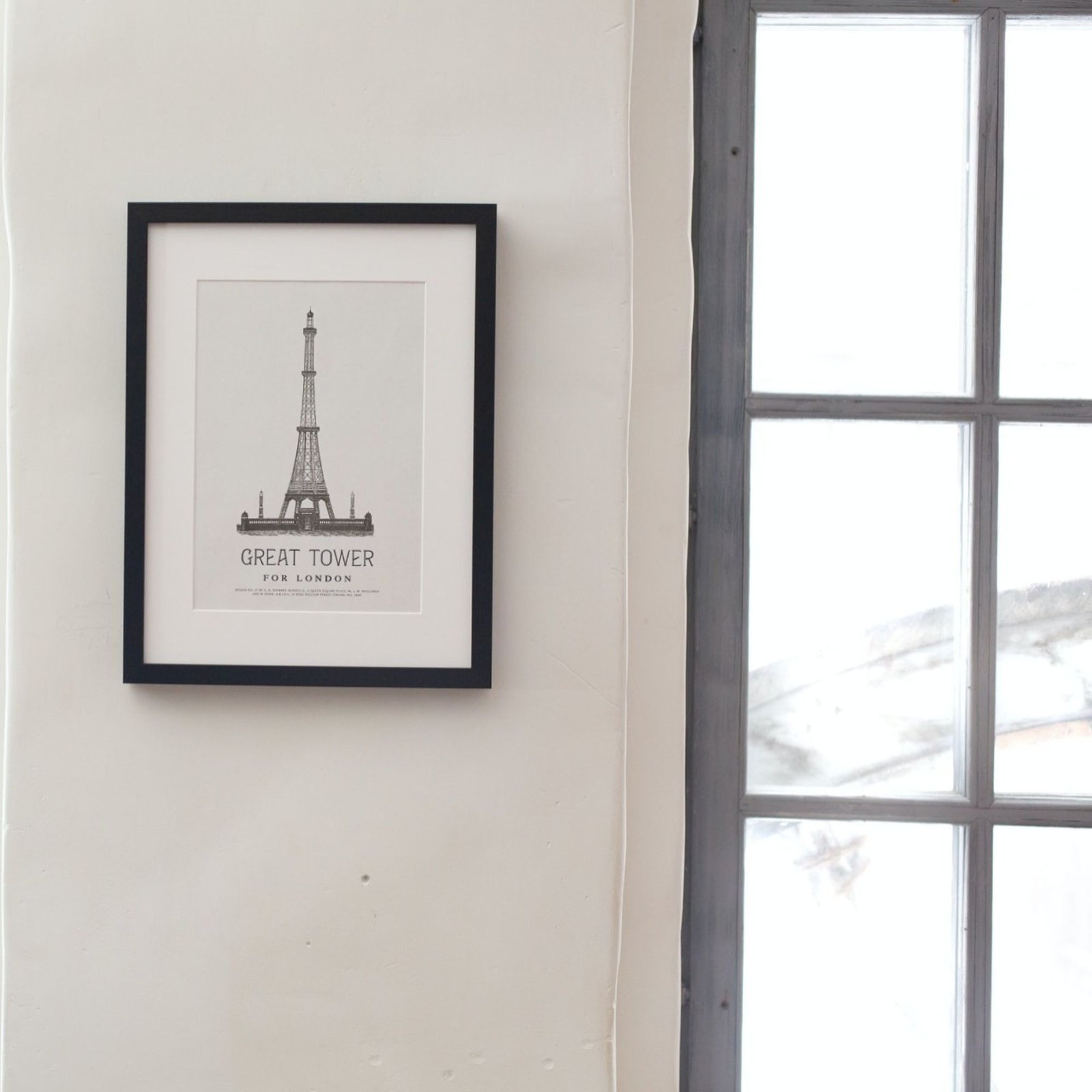 Framed Eiffel Tower print beside window
