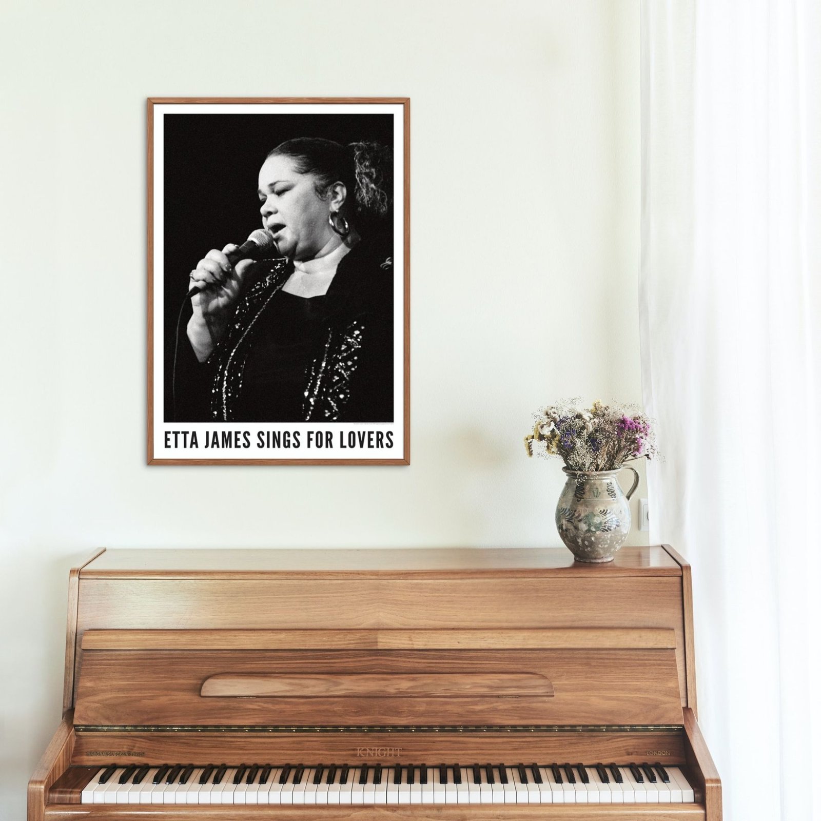 Black and white poster above wooden piano.
