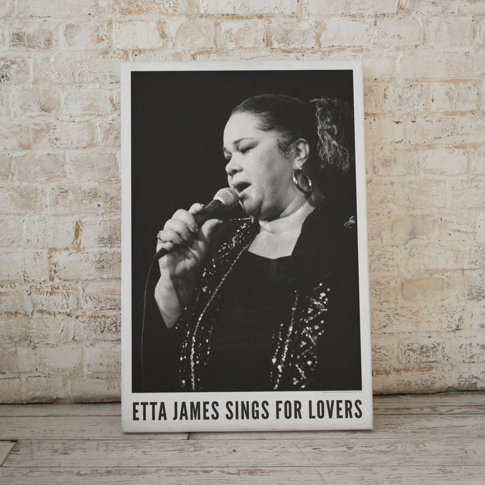 Singer holding microphone, black and white poster.