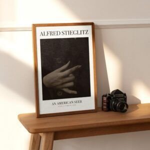 Alfred Stieglitz framed photo beside vintage camera.