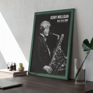 Framed black and white saxophonist poster on desk.